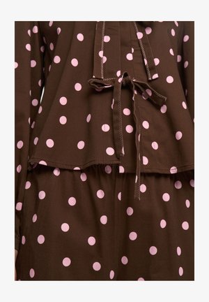 Brązowy strój w grochy z różowymi grochami, wiązaniem w talii, miękką fakturą i warstwowym krojem na górze i spodniach.