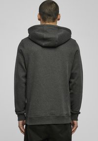 Grey hooded sweatshirt, cotton blend material, ribbed cuffs and hem, features a large hood, and minimalist design with no visible logos.