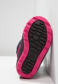 Sort atletiske sko sål med en struktureret sort gummibund, der har en tyk pink mellemsål og markante dækmønstre.