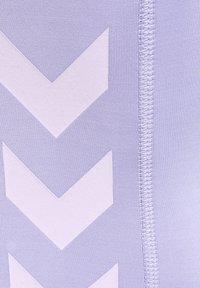 Ljuslila stretchigt tyg med vita sicksackmönster och synliga sömndetaljer. Mjuk textur, designad för komfort och flexibilitet.