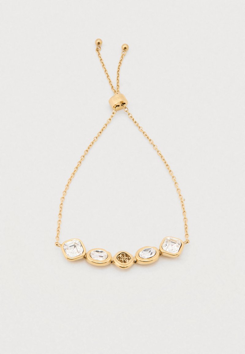 Pulseira de ouro com cinco cristais transparentes de diferentes formas, assentados em molduras metálicas suaves, com uma corrente delicada e fecho ajustável.