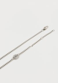 Αλυσίδα λαιμού από ασήμι με κυκλικό μενταγιόν χαραγμένο με τη λέξη "DEL" και κούμπωμα με γαντζάκι σε λευκό φόντο.