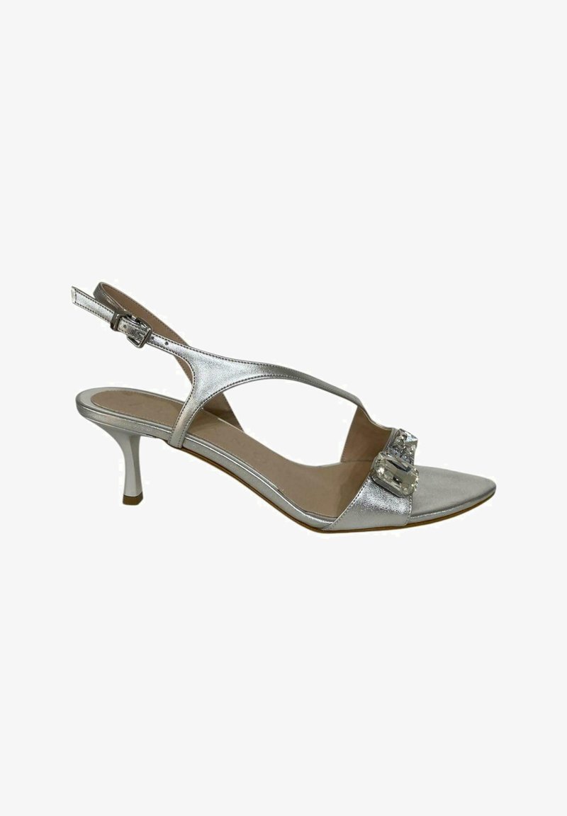 Scarpa slingback argento con una finitura metallica liscia, punta aperta e una fibbia decorativa in pietra preziosa trasparente sul collo del piede. Presenta un tacco sottile.