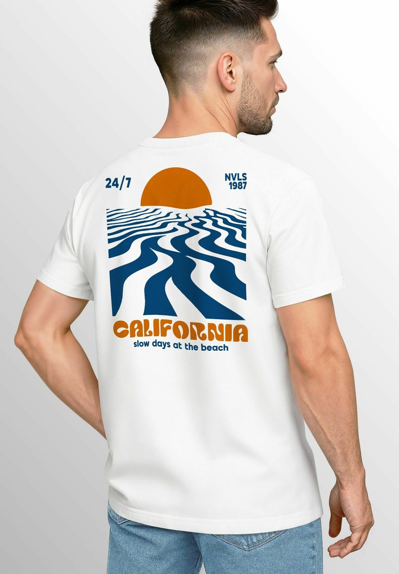 Weißes Baumwoll-T-Shirt mit einem grafischen Druck eines Sonnenuntergangs über wellenförmigen blauen Linien sowie dem Text "CALIFORNIA Slow Days at the Beach".
