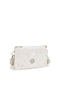 Borsa di stoffa bianca con motivo floreale, chiusura con zip e logo circolare. Include una tracolla rimovibile e hardware in tonalità argento.