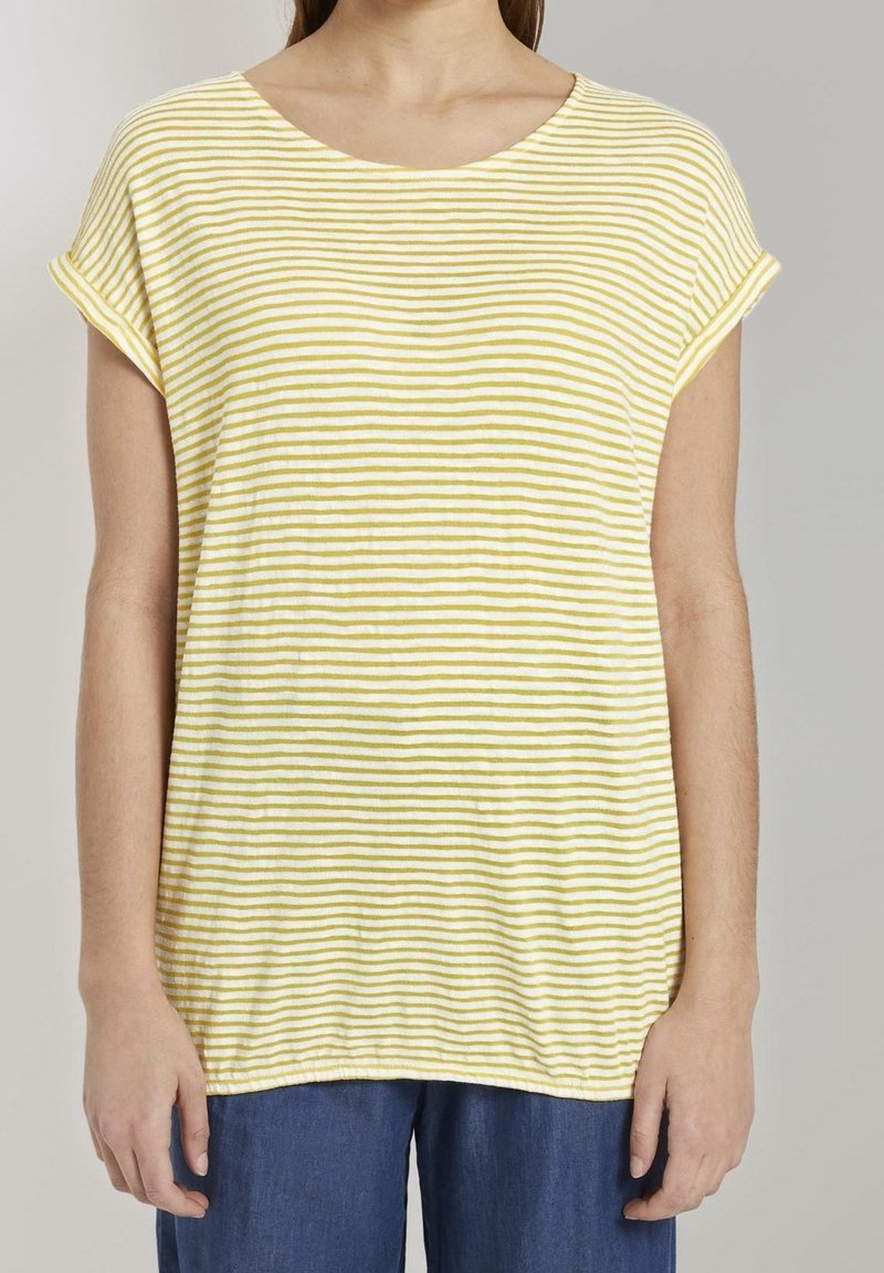 Camiseta de manga corta a rayas amarillas y blancas con cuello redondo y corte relajado, hecha de una tela suave. El dobladillo tiene una ligera curva.