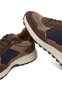 Sneakers in suede marrone con dettagli blu navy, punta rotonda, superficie testurizzata, suola bianca a contrasto e lacci marroni. Dettagli perforati visibili.