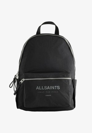 Zwarte rugzak met voorvak met rits en zilveren ritsen, met "ALLSAINTS" en Japanse tekst boven "LONDON" op het vak.