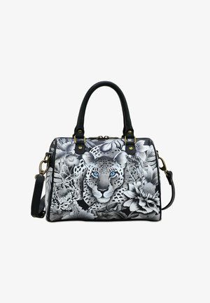 Black and white handbag featuring a leopard print design with blue eyes, floral patterns, black leather handles, and gold hardware accents.