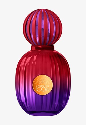 Flacon de parfum côtelé rouge et violet avec bouchon sphérique et étiquette dorée portant l'inscription « Banderas The Icon » sur fond blanc.