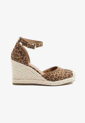 Sandalia cuña con estampado de leopardo, con un empeine de tela texturizada, correa al tobillo y tacón de yute trenzado. Presenta una puntera redondeada y un interior acolchado.