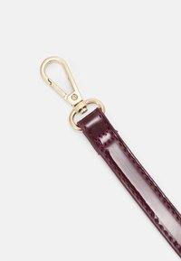 Burgundy leather strap with a glossy texture, featuring gold-tone metal hardware and a swivel clasp for attachment.