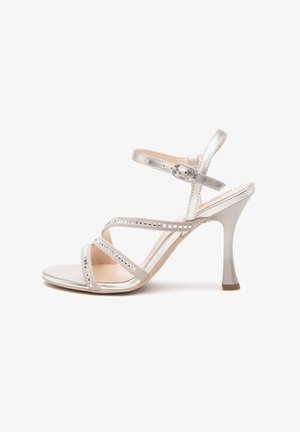 Silberne High-Heel-Sandalen mit drei zarten Riemen, die quadratische Ausschnitte, einen Schnallenknöchelriemen und eine glatte, glänzende Oberfläche aufweisen.
