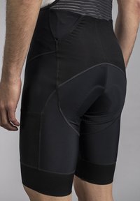 Black cycling shorts made of stretchy fabric, featuring a padded area, tight fit, flat seams, and a textured waistband for comfort.