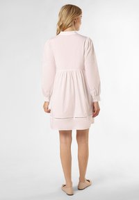 Helles pinkes Kleid mit gerafftem Taillenbereich, langen Puffärmel und bestickten Details an den Ärmeln. Glattes Material, knielanges Design und schlichter Kragen.