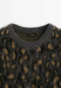 Pull gris foncé duveteux avec motif léopard marron et encolure ronde, comportant une étiquette noire à l'intérieur du col.