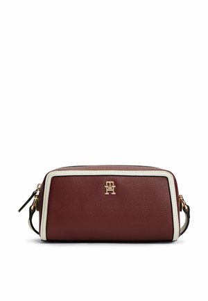 Pochette rectangulaire en cuir bordeaux avec bordure blanche, logo doré et bracelet en cuir noir sur fond blanc.