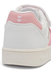 Biała sneaker z różowymi akcentami, z teksturowaną podeszwą, wyściełanym kołnierzem i trójkątnym detalem na pięcie.