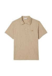 Beige polotröja gjord av mjukt bomull, med krage, korta ärmar och en liten, broderad logotyp på vänster bröst.