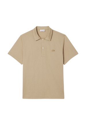 Beige polo paita, joka on valmistettu pehmeästä puuvillasta, ja siinä on kauluspääntie, lyhyet hihat sekä pieni, brodeerattu logo vasemmassa rinnassa.
