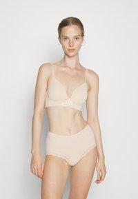 Light beige bra with a plunging neckline, thin straps, and a lace accent at the center. Matching high-waisted briefs with lace trim.