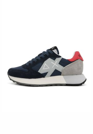 Sneakers in suede blu navy con accenti grigi e tab del tallone rosso. Presentano una tomaia in tessuto texture, punta rotonda e suola intermedia in contrasto. Suola in gomma.