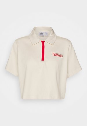 Polo Adidas crème à manches courtes avec fermeture éclair rouge et logo sur la poitrine gauche, avec col classique et coupe courte.