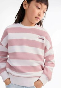 Felpa a righe rosa chiaro e bianca con scollo rotondo, tessuto testurizzato e la scritta "Dreamer" ricamata in bordeaux sul petto.