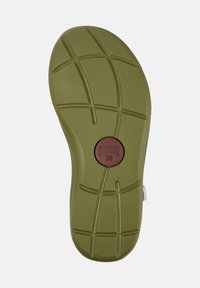 Green rubber shoe outsole with a textured surface and traction pattern. Brown circular label displays size 38.