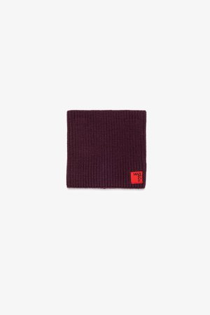 Bonnet en tricot bordeaux avec texture côtelée et une étiquette de marque rouge. Forme rectangulaire adaptée pour les couvre-chefs. Léger et flexible.