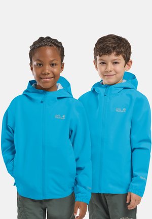 Due bambini indossano giacche con cappuccio Jack Wolfskin di un azzurro brillante, in piedi uno accanto all'altro, sorridenti su uno sfondo semplice.
