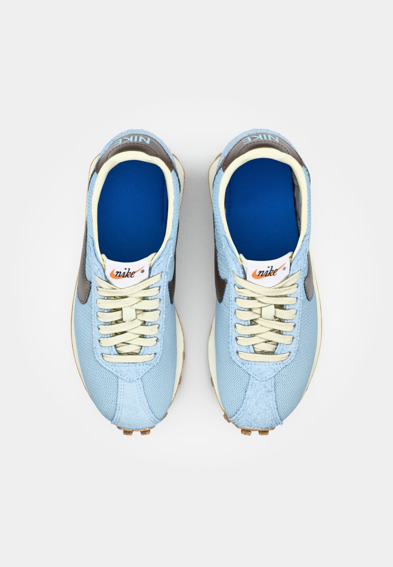 Jasnoniebieskie buty sportowe z siateczki i zamszowymi akcentami. Kremowe sznurowadła i podeszwa. Niebieskie wnętrze. Logo Nike na języku i boku.