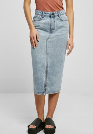 Lichtblauwe denim midi-rok met splits aan de voorkant, hoge taille en vijf zakken. Gekleed met zwarte plateau-sandalen. Soepele textuur.