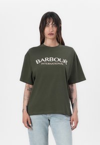Roheline puuvillane T-särk lühikeste varrukatega, millel on valge "BARBOUR INTERNATIONAL" logo. Lihtne, mugav lõige.