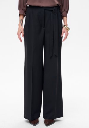 - Spodnie materiałowe