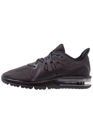 Zwarte Nike Air Max sneaker met mesh bovenwerk, gevoerde zool, zichtbare luchtunit en vetersluiting, zijaanzicht.
