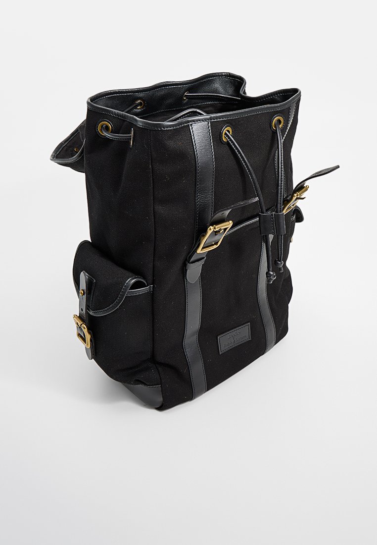 Schwarze Leinentasche mit schwarzen Lederelementen, Kordelzugverschluss und goldenen Beschlägen. Verfügt über eine rechteckige Basis und verstellbare Träger.