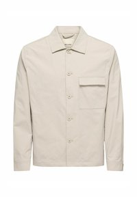 Veste beige clair en coton, dotée d'un col pointu, de boutons sur le devant et d'une poche poitrine. Texture lisse avec des manches longues.