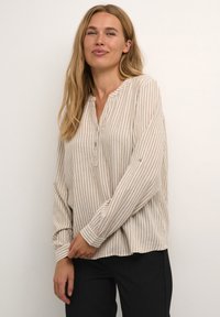 Beige und weiß gestreifte Bluse mit einem Reverskragen, langen Ärmeln und geknöpften Manschetten, aus leichtem Stoff.