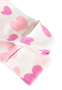 Écharpe en tissu léger avec une base blanche ornée de grands motifs en forme de cœur rose. Les bords sont repliés et la texture est légèrement nervurée.