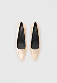 Guldglänsande patentläderballerina med spetsig tå, slät yta och svart inredning. Har subtil märkning på innersulan.