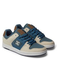 Baskets avec une tige en daim et textile bleu et crème, dotées de lacets bleus, d'accents en cuir marron et d'une semelle en caoutchouc blanche avec des détails texturés.