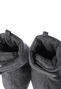 Dunkelgraue, weiche Stoffhausschuhe mit aufgerolltem Bündchen, die eine glatte Textur und ein rundes Zehendesign aufweisen. Keine sichtbaren Muster oder Metallteile.