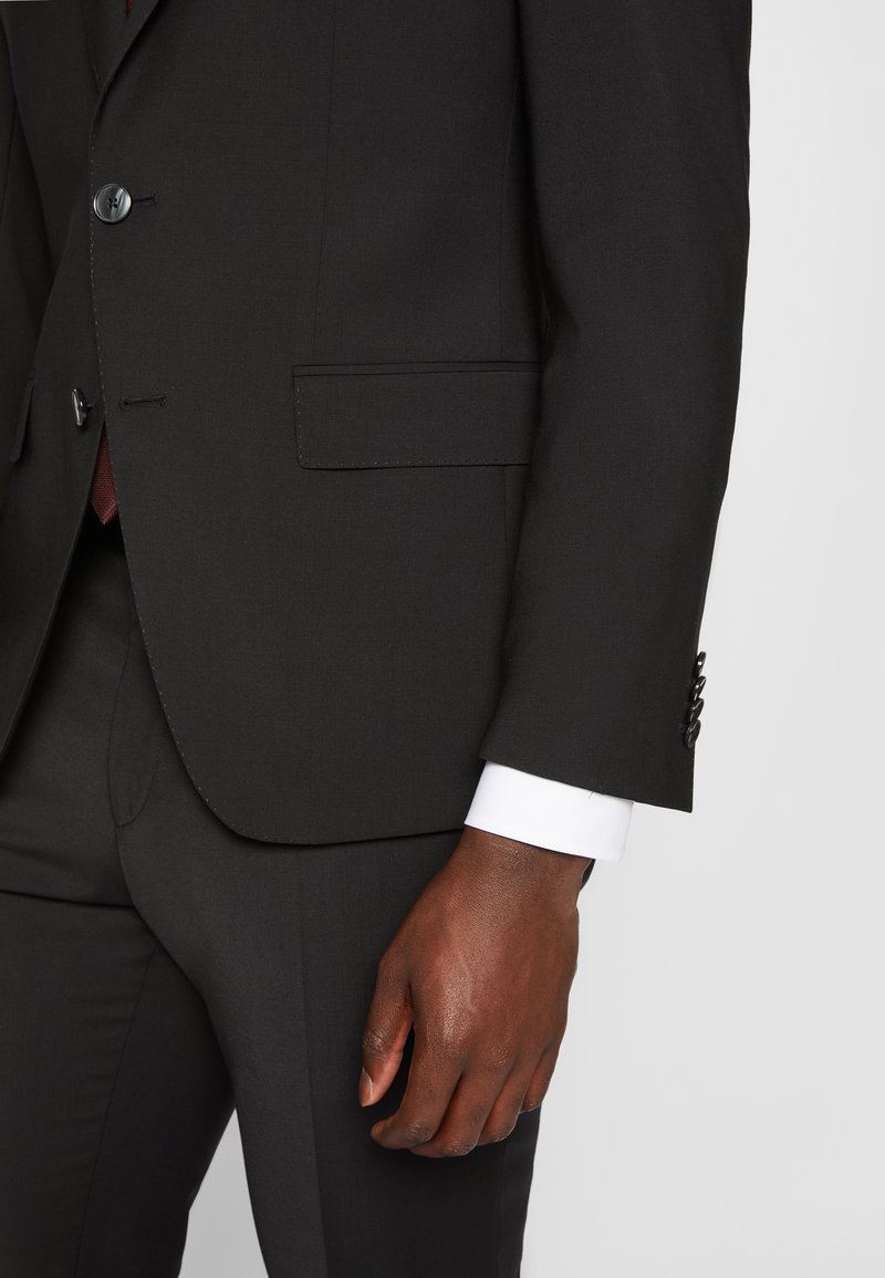 Zwarte colbert met een notch-lapel, twee knopen en een zak. De manchet van een witte dressshirt is zichtbaar. Glad stof met een subtiele textuur.