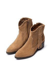 Botas de ante marrón hasta el tobillo con punta afilada, cremallera lateral y detalle de borlas. Los tacones son negros, ofreciendo un acabado contrastante.