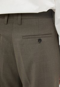 Grå ullblandning byxor med en slät textur, med en bakficka och knappdetalj. Skräddarsydd passform och pressad veck längs benet.