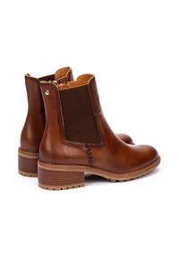 Braune Leder-Ankle-Boots mit elastischen seitlichen Einsätzen, runder Spitze, glatter Textur und niedrigem Holzabsatz. Auffällige Nahtdetails an der Seite.