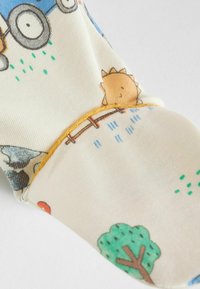 Színes pamut zokni, amely vidám mintákkal díszített, beleértve egy napot, fákat és esőcseppeket, a lábujjnál kontrasztos sárga varrással.