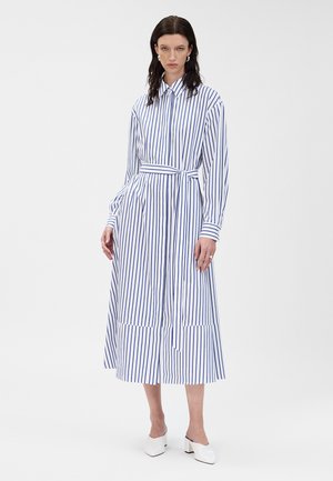 Abito midi a righe in cotone bianco e blu, con bottoni frontali, maniche lunghe, vita con cintura e orlo a strati.
