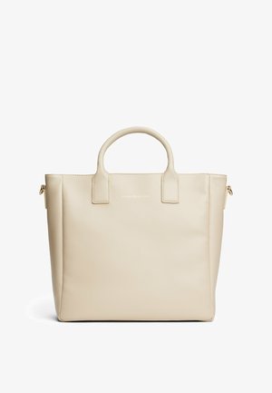 Beige draagtas van soepel leer. Heeft twee bovenhandvatten, een ritszak aan de zijkant en een subtiele, op de voorkant gegraveerde logo.